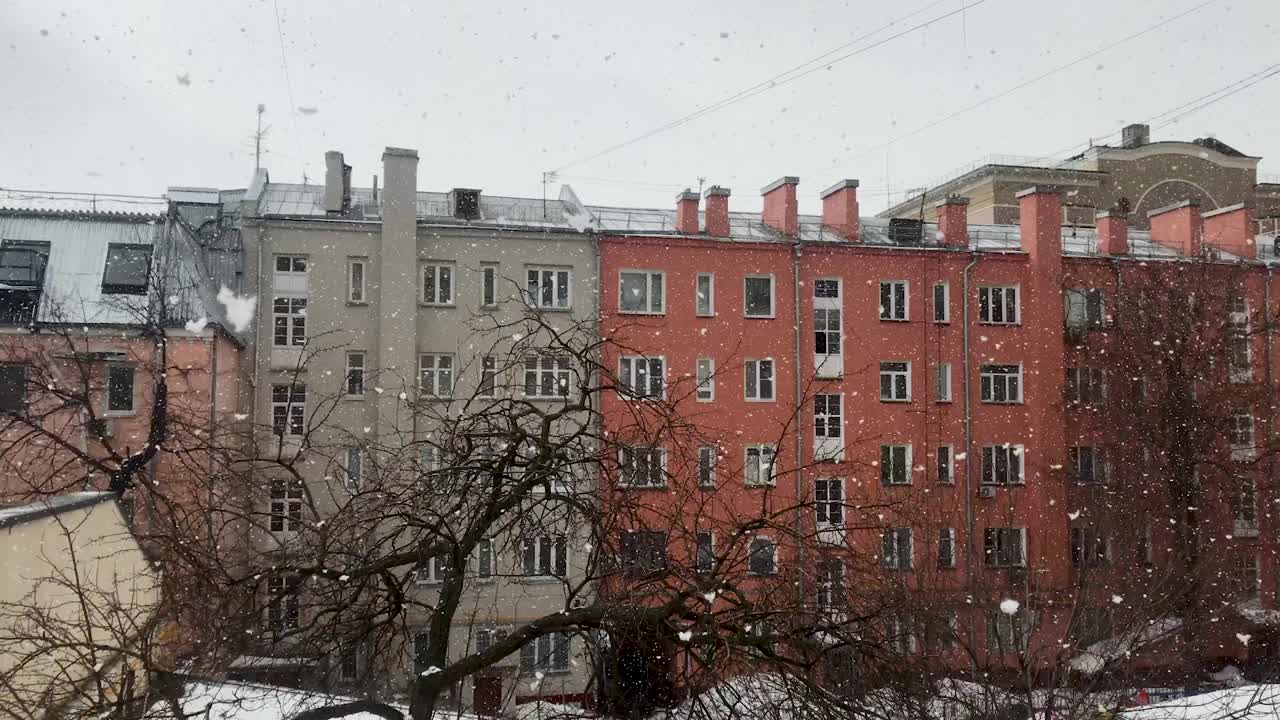 美丽的雪落在城市里。大片雪花飘落，盘旋着视频素材