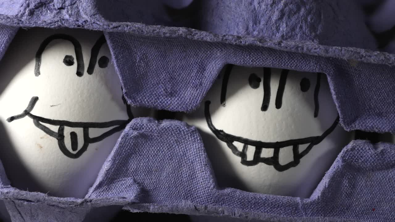 两个蓝色托盘中间画着笑脸的白色鸡蛋视频下载