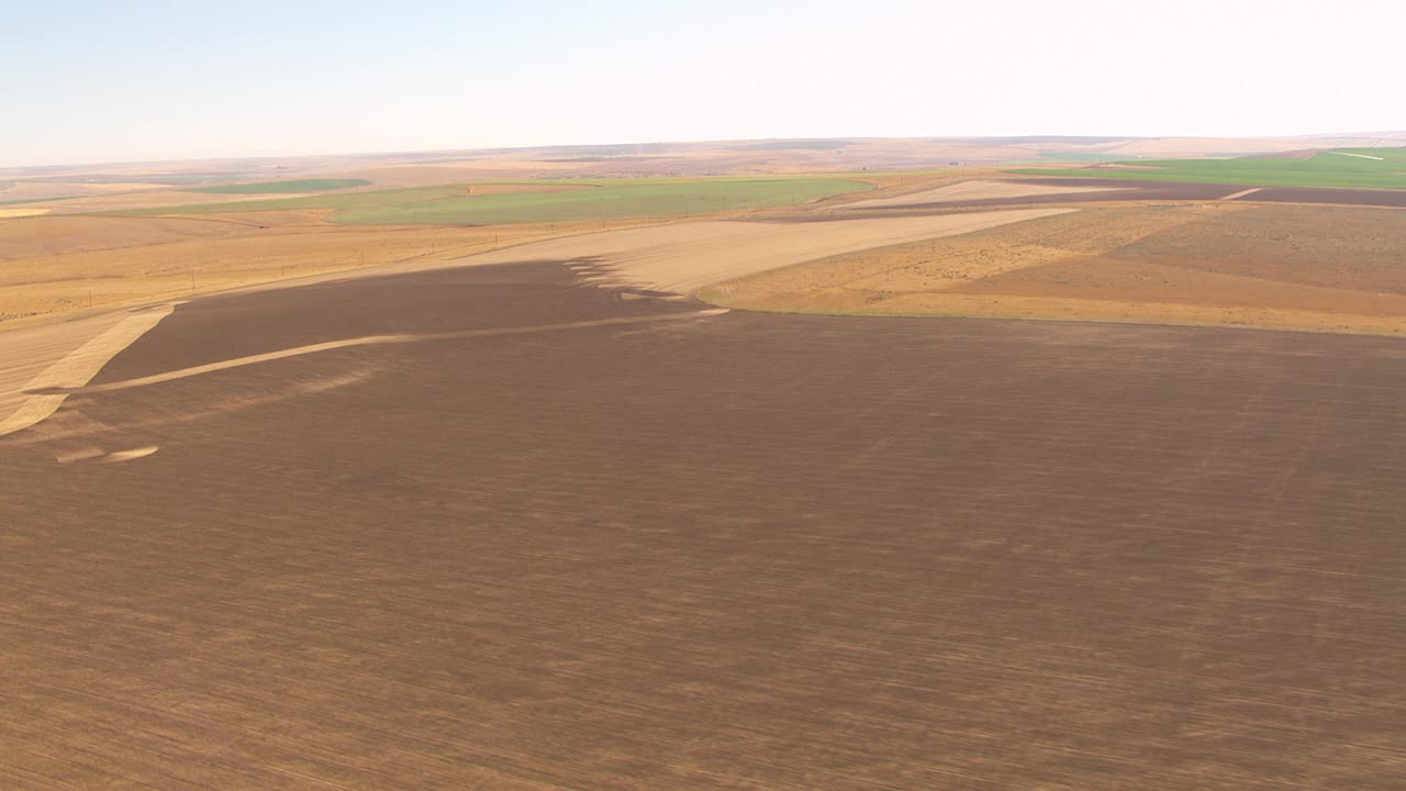 新鲜耕作的棕色农田准备播种。视频下载