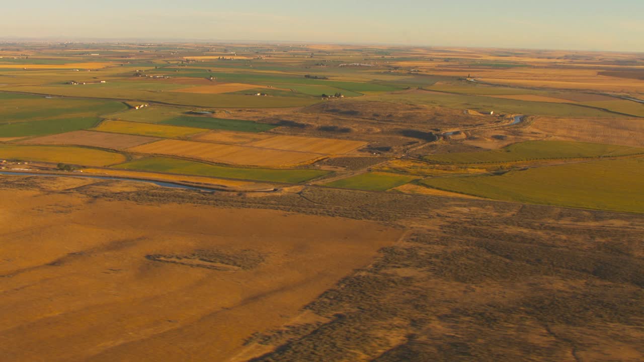 绿色农田灌溉周围的棕色干燥自然环境。视频下载