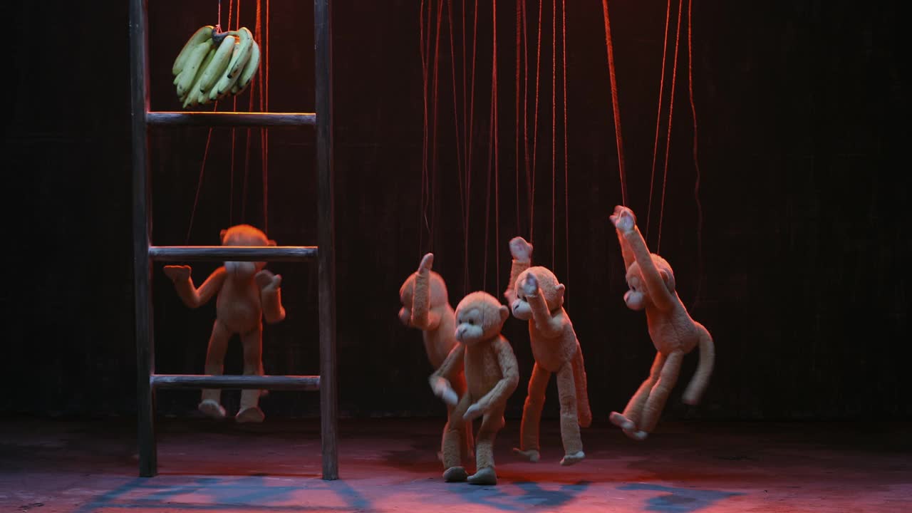 中等镜头的猴子木偶试图抓住香蕉挂在木偶戏视频下载