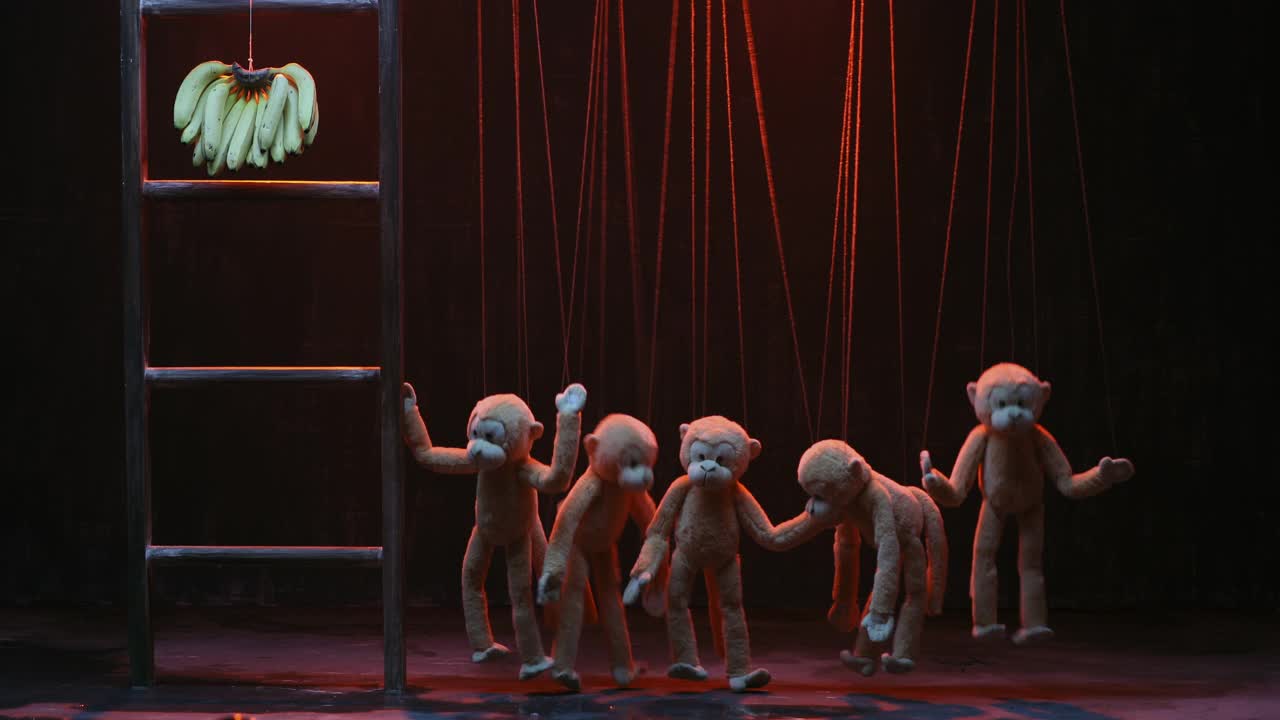 中镜头的猴子木偶试图抓住香蕉挂在木梯在雨木偶表演视频下载