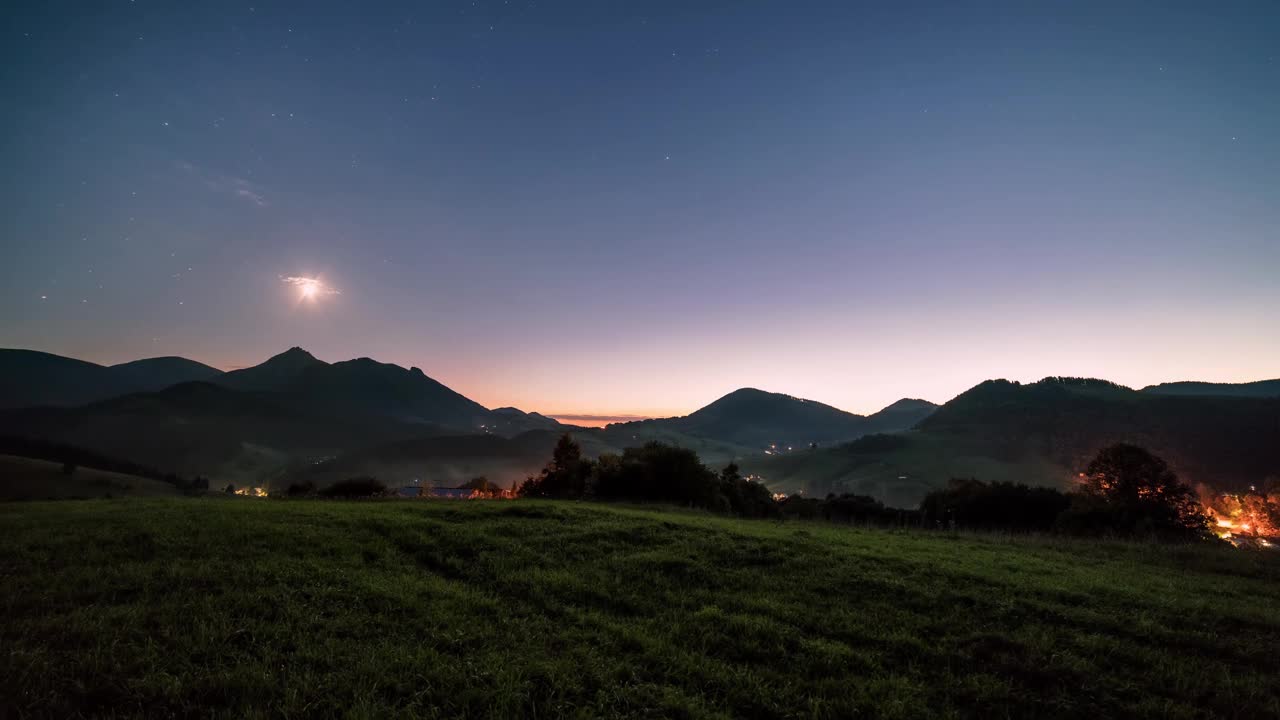 蓝色星空与星星和月亮的光在乡村乡村在高山景观天文时间流逝视频下载