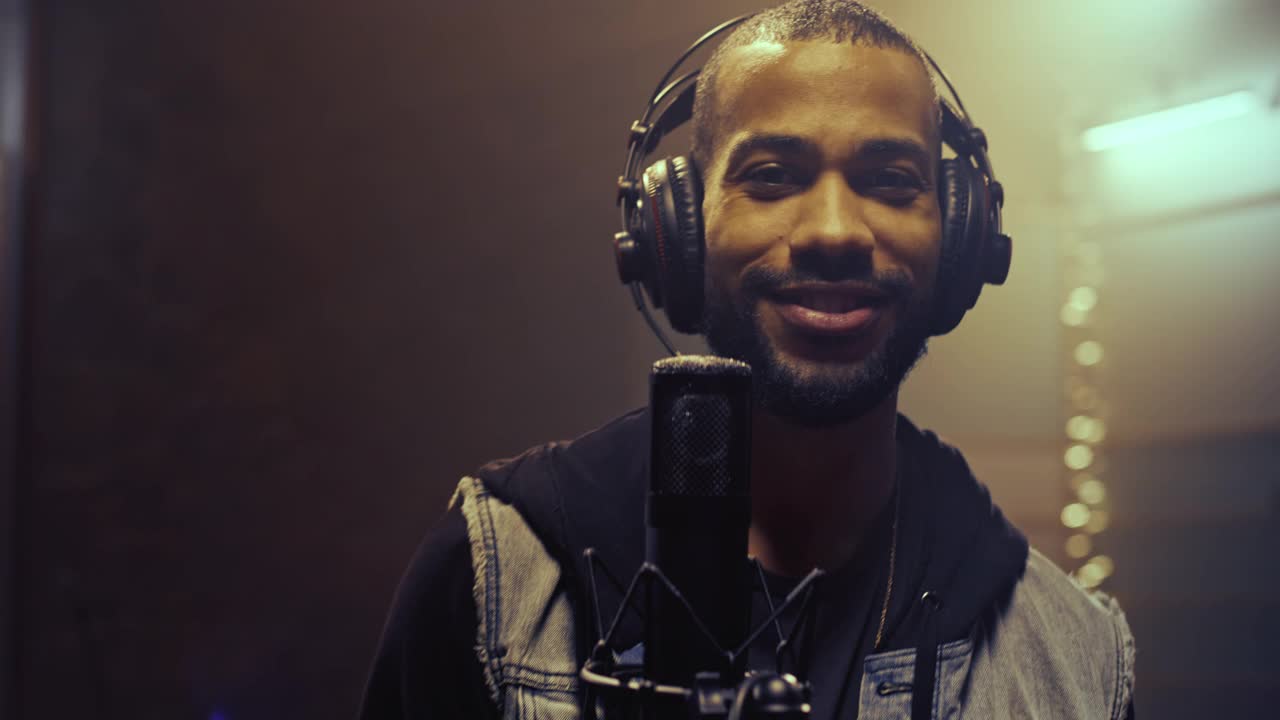 一个微笑的男歌手在录音室的肖像视频素材