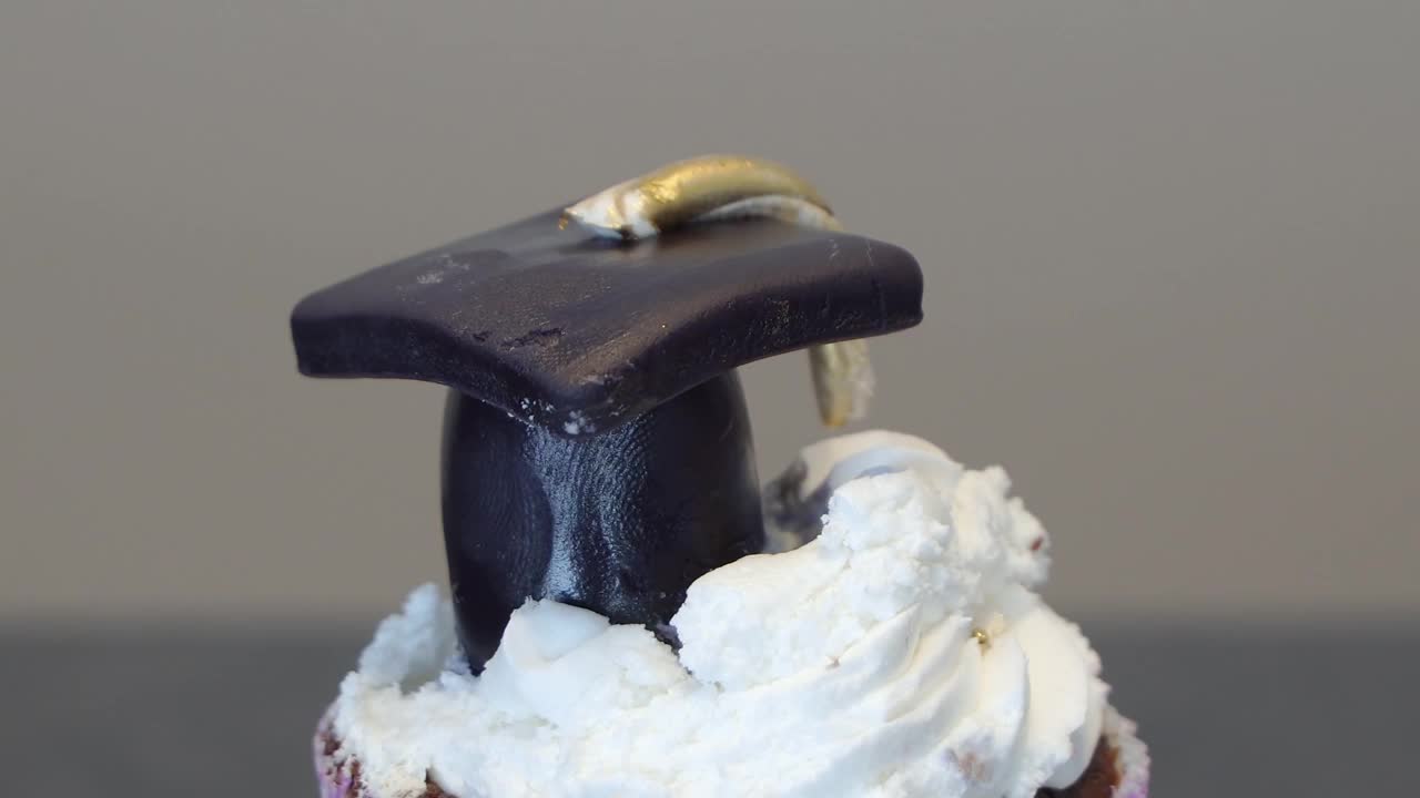 紫色和黑色的巧克力纸杯蛋糕，上面还有毕业帽视频下载