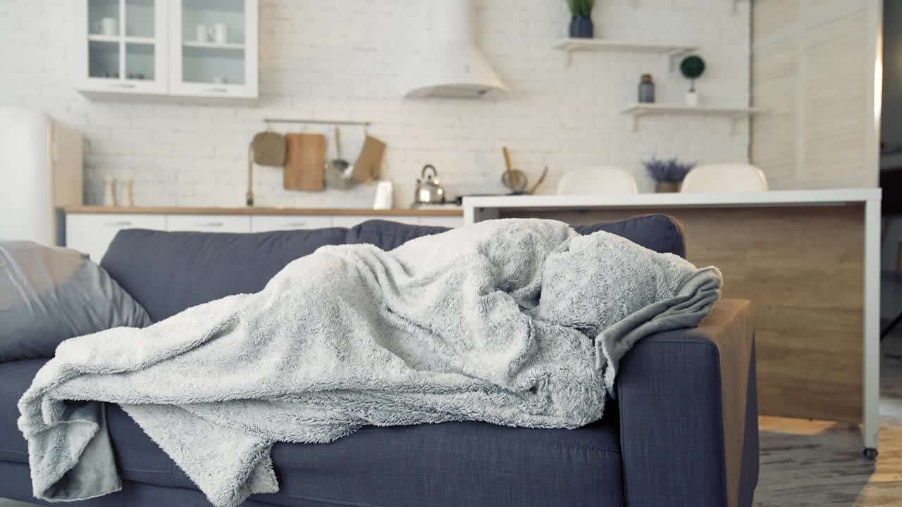 一名男子因感冒和流感症状躺在家里的沙发上。大流行。视频下载