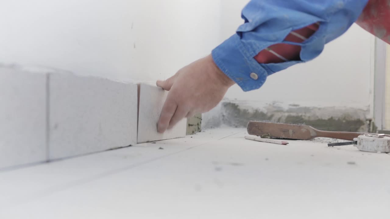 瓷砖工人正在地板和墙壁上铺新瓷砖。视频下载