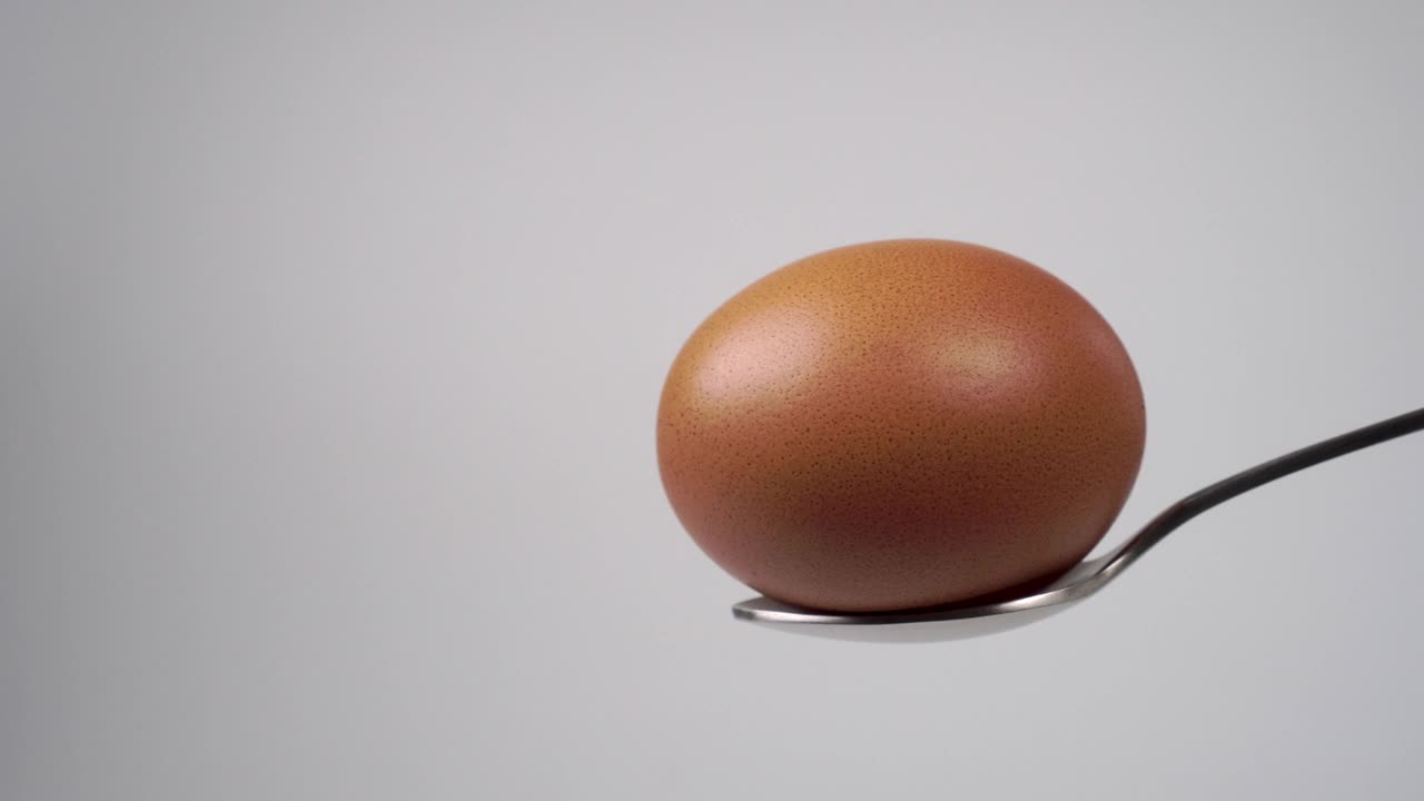 一个生鸡蛋放在金属勺子里视频下载