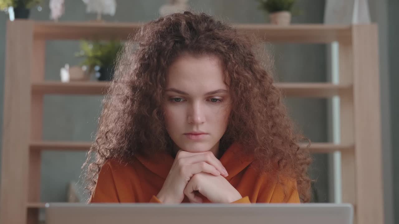专注的年轻卷发女企业家用笔记本电脑思考工作视频下载