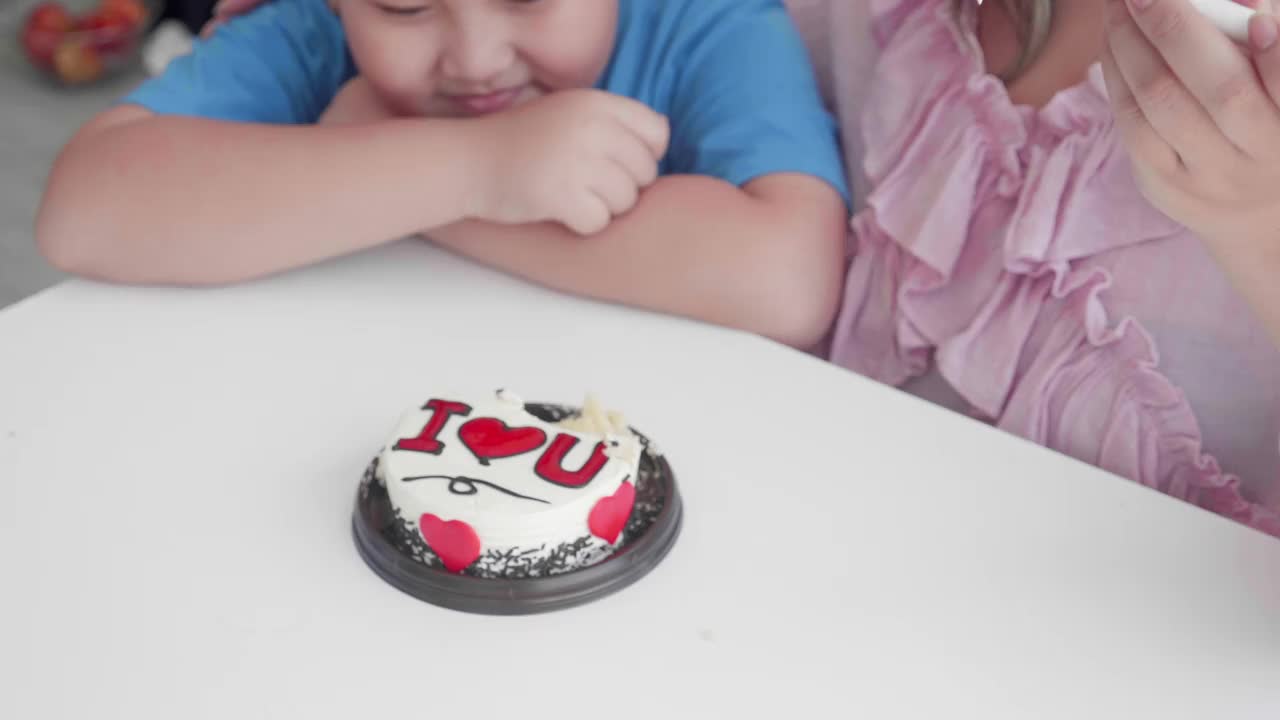 亚洲家庭关系以母子在家里吃蛋糕庆祝生日，幸福男孩与母亲在派对上一起拥抱庆祝，两人，母亲节，节日概念。视频下载