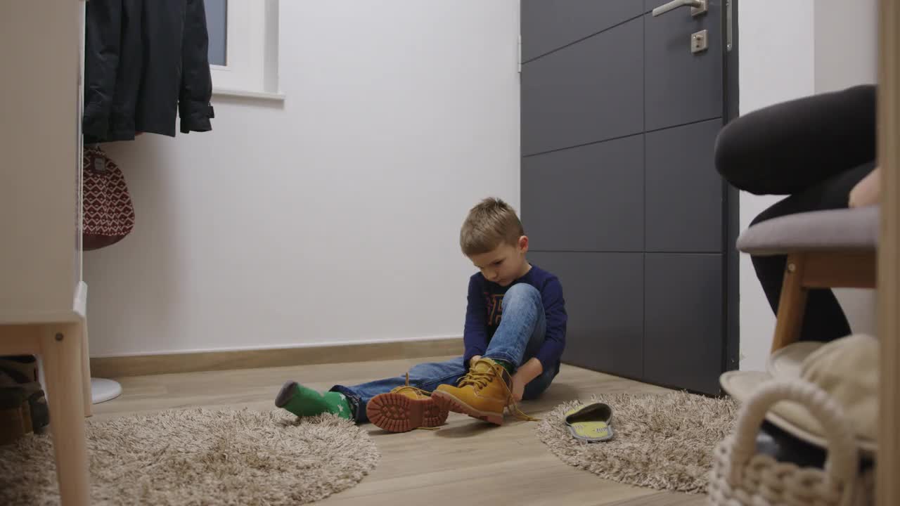 小男孩在妈妈的帮助下穿鞋视频下载