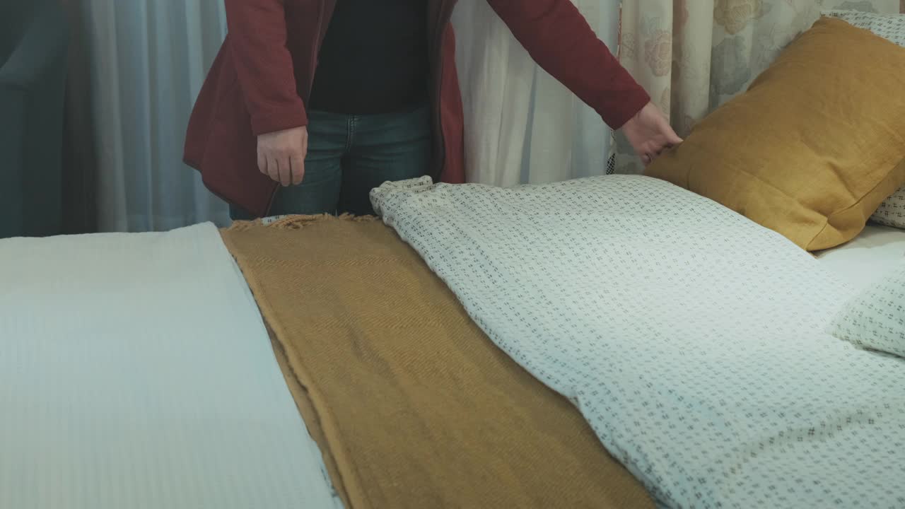 一个白人妇女在酒店房间里整理床铺视频下载