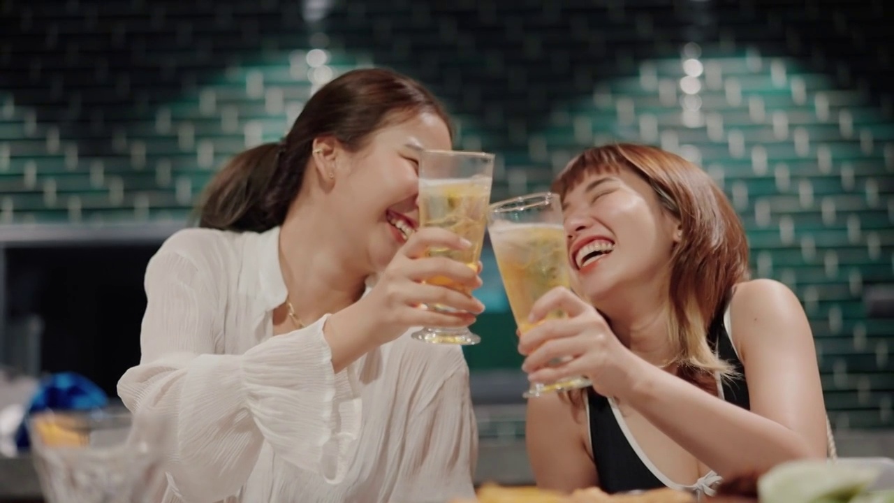 快乐的女人在派对上喝着酒精饮料和她最好的朋友。视频素材