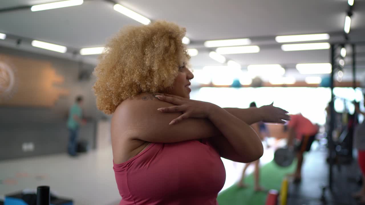 一个年轻女子在健身房伸展手臂的肖像视频下载