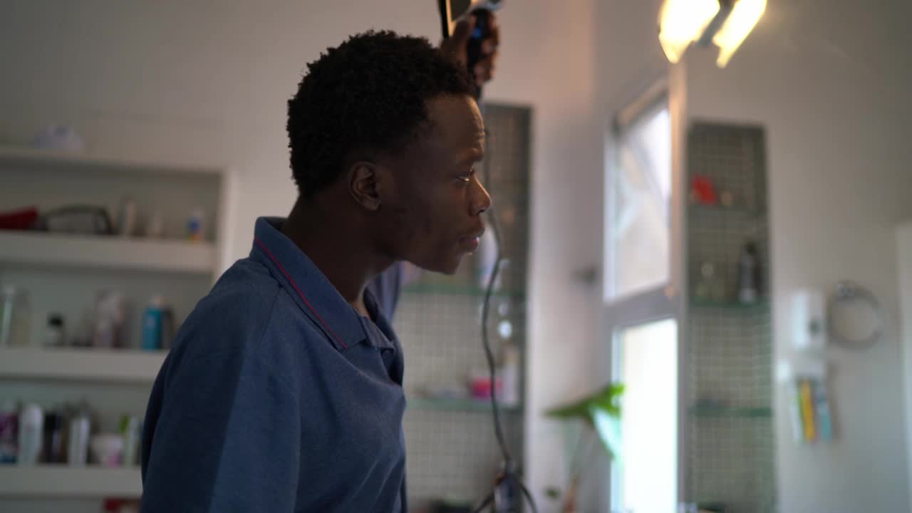 年轻男子梳头和干燥的非洲式发型在早上在家视频下载