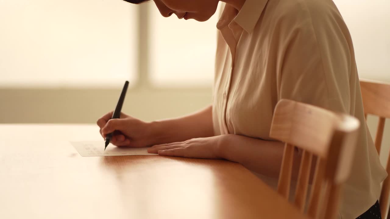 一个女人正在用毛笔写信视频素材
