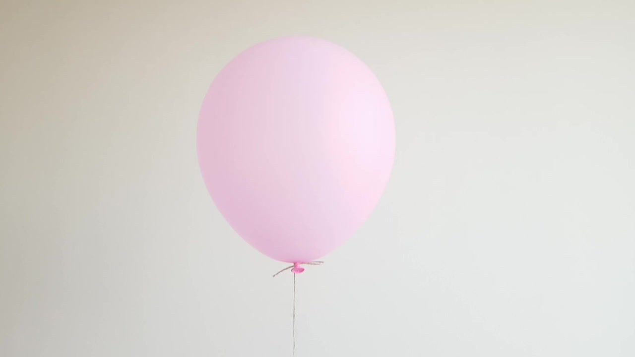 粉色的轻氦气球漂浮在白色的墙上，庆祝，生日的概念视频下载