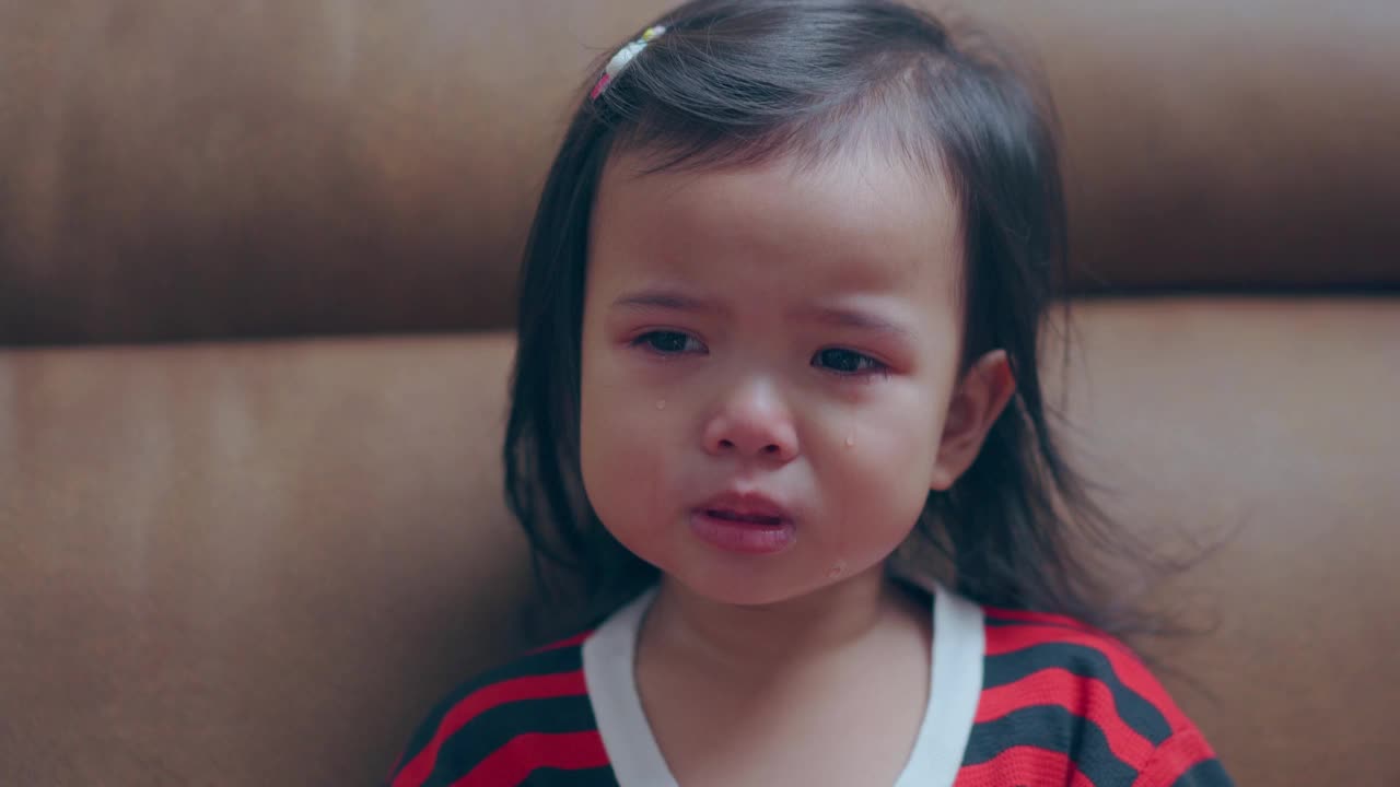 亚洲小女孩独自坐在那里哭着，眼泪从她的眼睛里掉下来视频下载