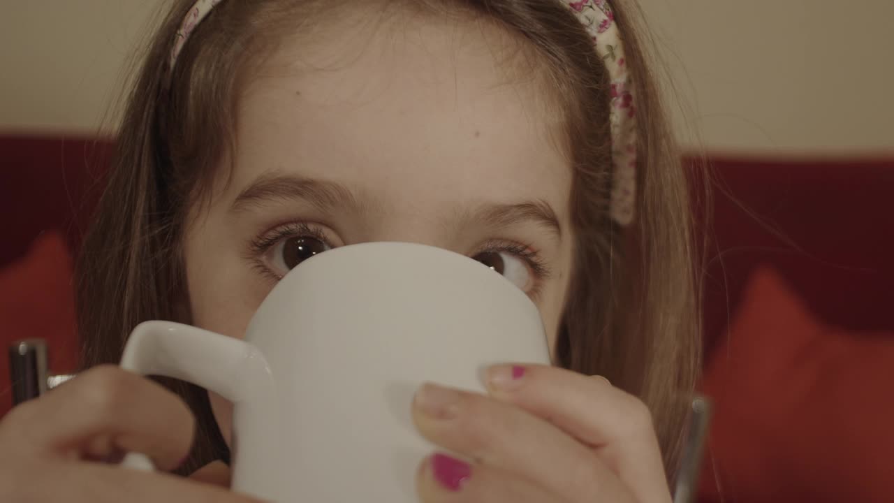 可爱的小女孩喝着牛奶。视频素材