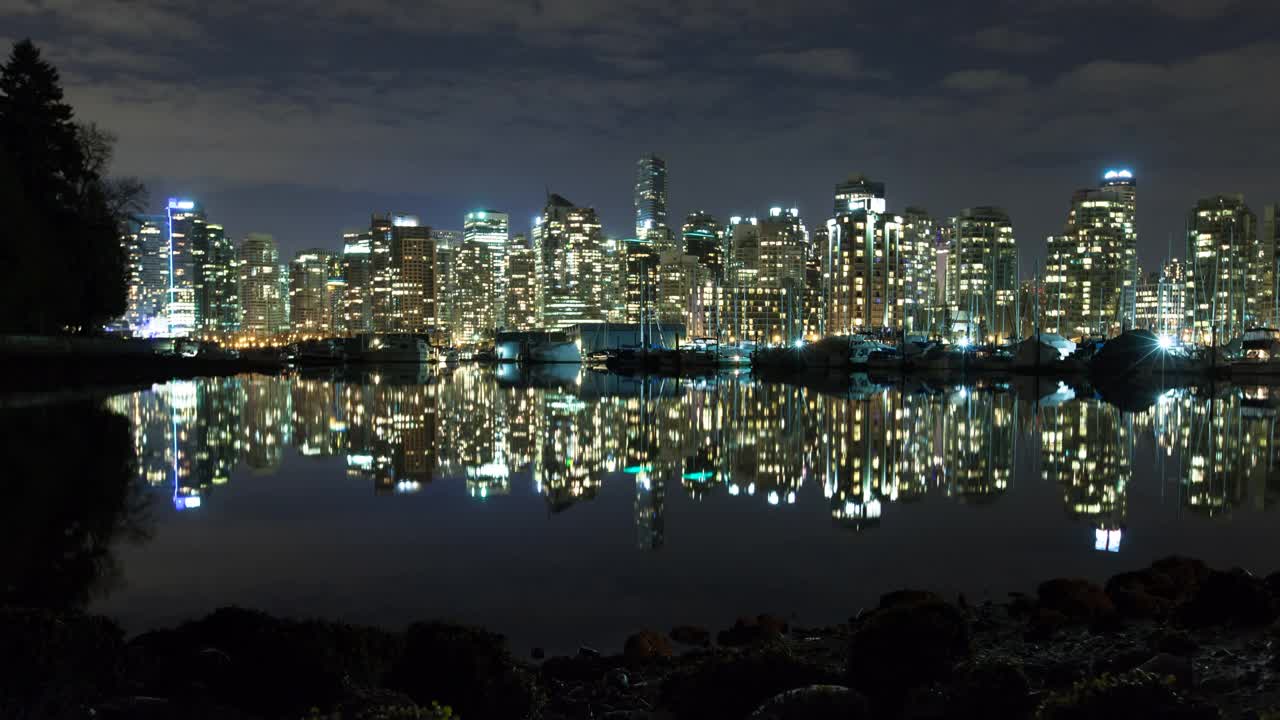时间推移反射的高大照明建筑在夜间在海上-温哥华，加拿大视频素材