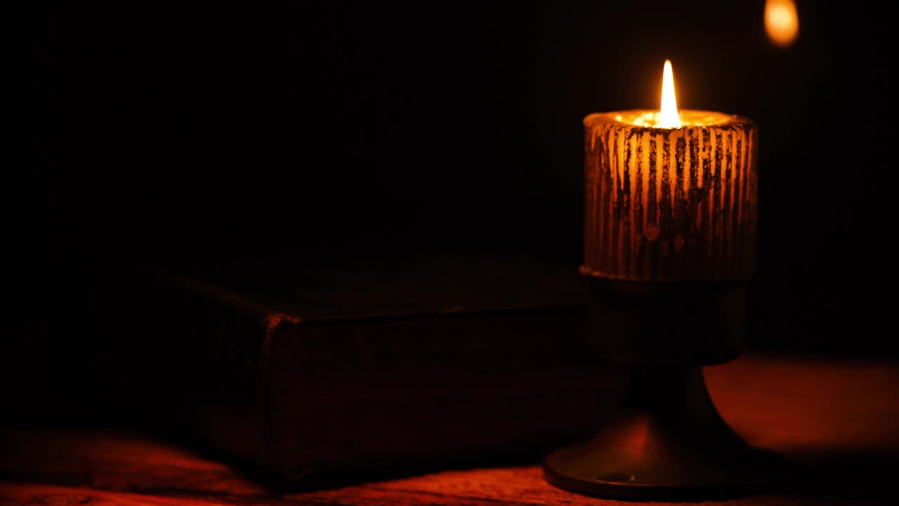 古老的城堡。用燃烧的蜡烛附上的光合着的古典书。视频素材
