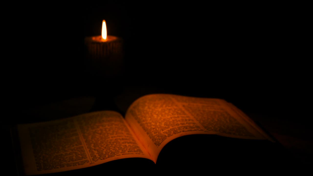 古老的城堡。《躺在桌上的古代经文》。燃烧的烛光照亮旧书。视频素材