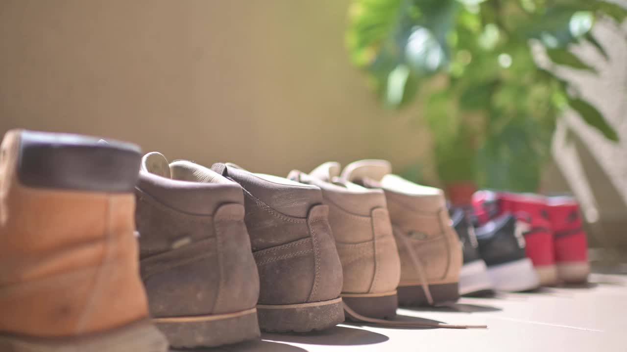 一排鞋在炎热的太阳下，在阳台旁边的室内植物视频素材