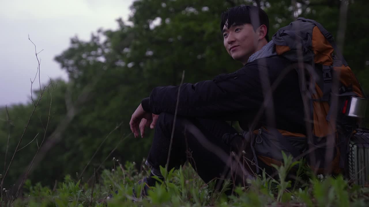 背包客——在韩国江原道江陵市安班德基村休息的年轻男子视频素材