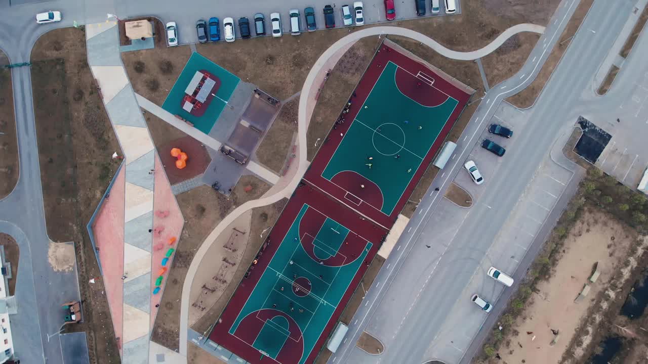 院子里的各种体育活动小区，为人口体育的发展提供了条件。无人机从附近的足球场、排球场、游乐场和滑板公园上空起飞视频素材