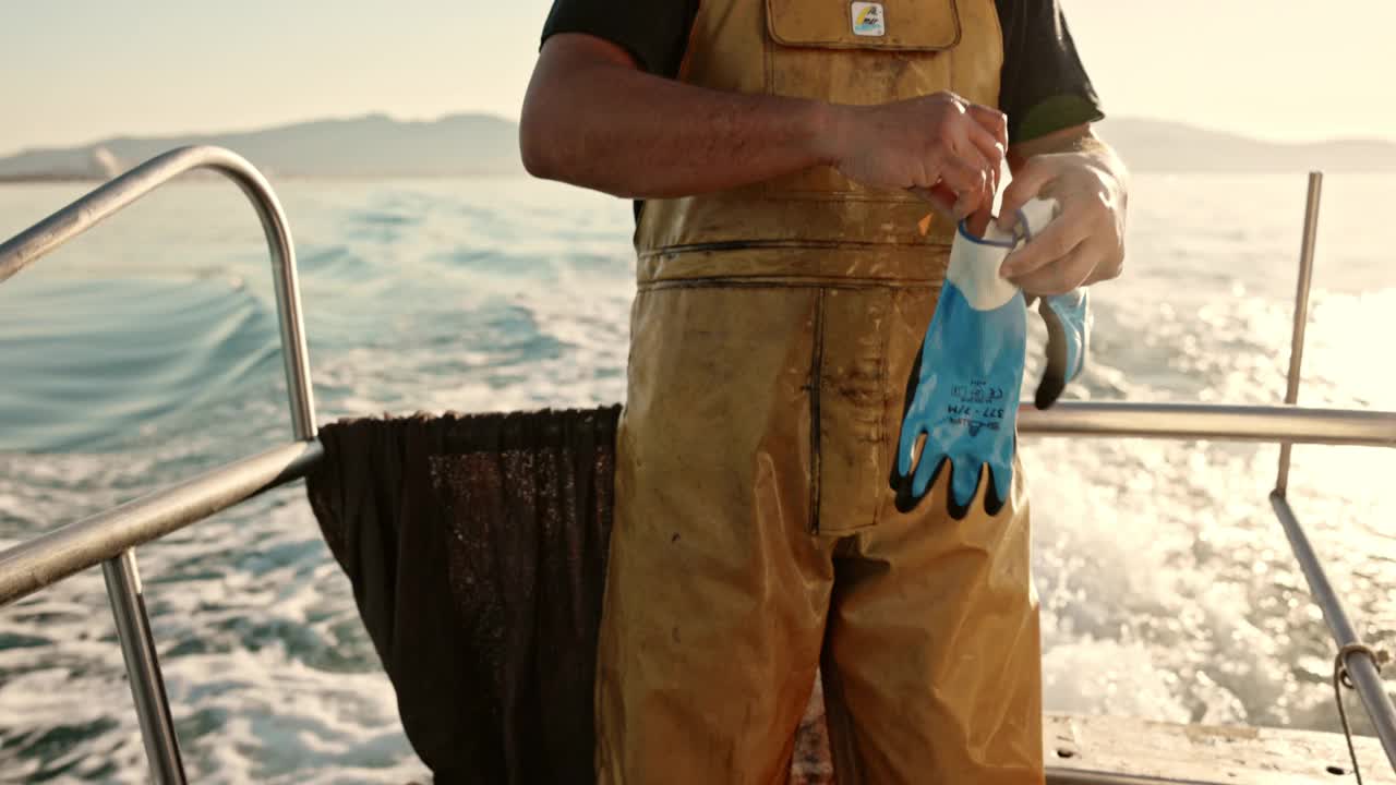 獨立漁民在海上戴上工作手套視頻下載