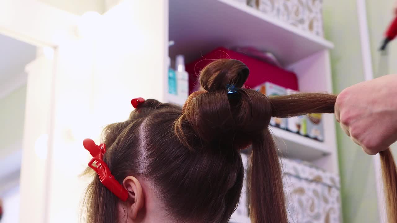 一个女孩在美容院用钳子夹起一绺头发视频下载
