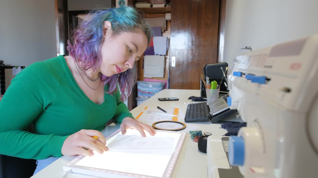 女人用浅色的桌子标定图纸进行刺绣视频下载