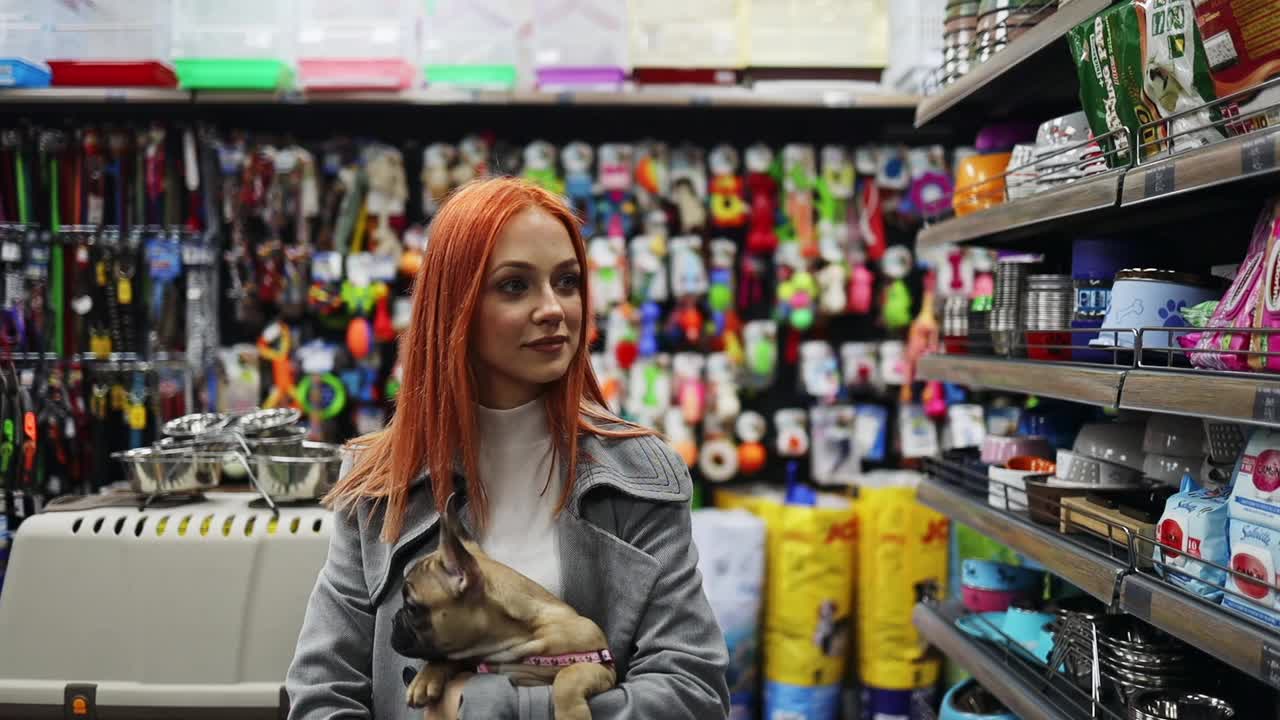 一个年轻的女人和她的狗在宠物店视频素材