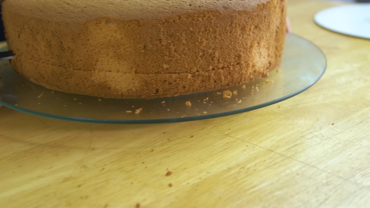 图为一名妇女用手切着烤好的饼干做甜蛋糕。视频下载
