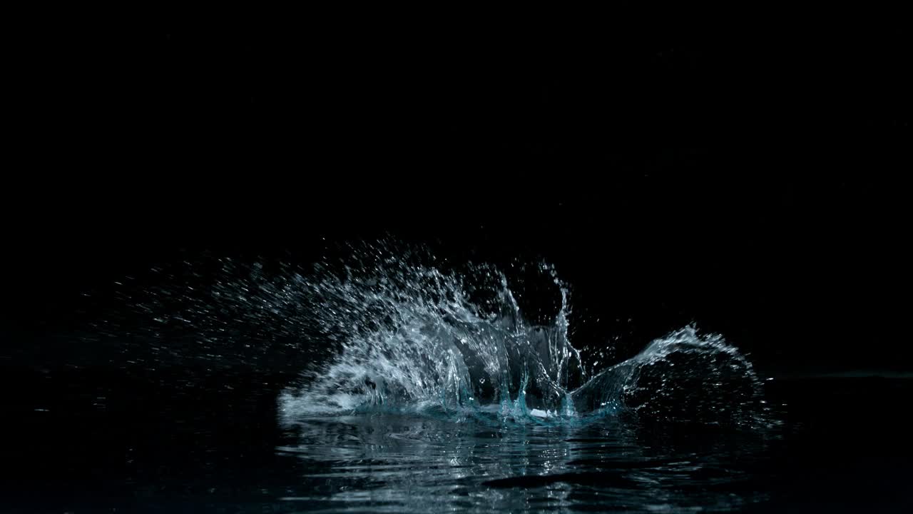 超级慢的运动水飞溅在黑色背景。视频下载