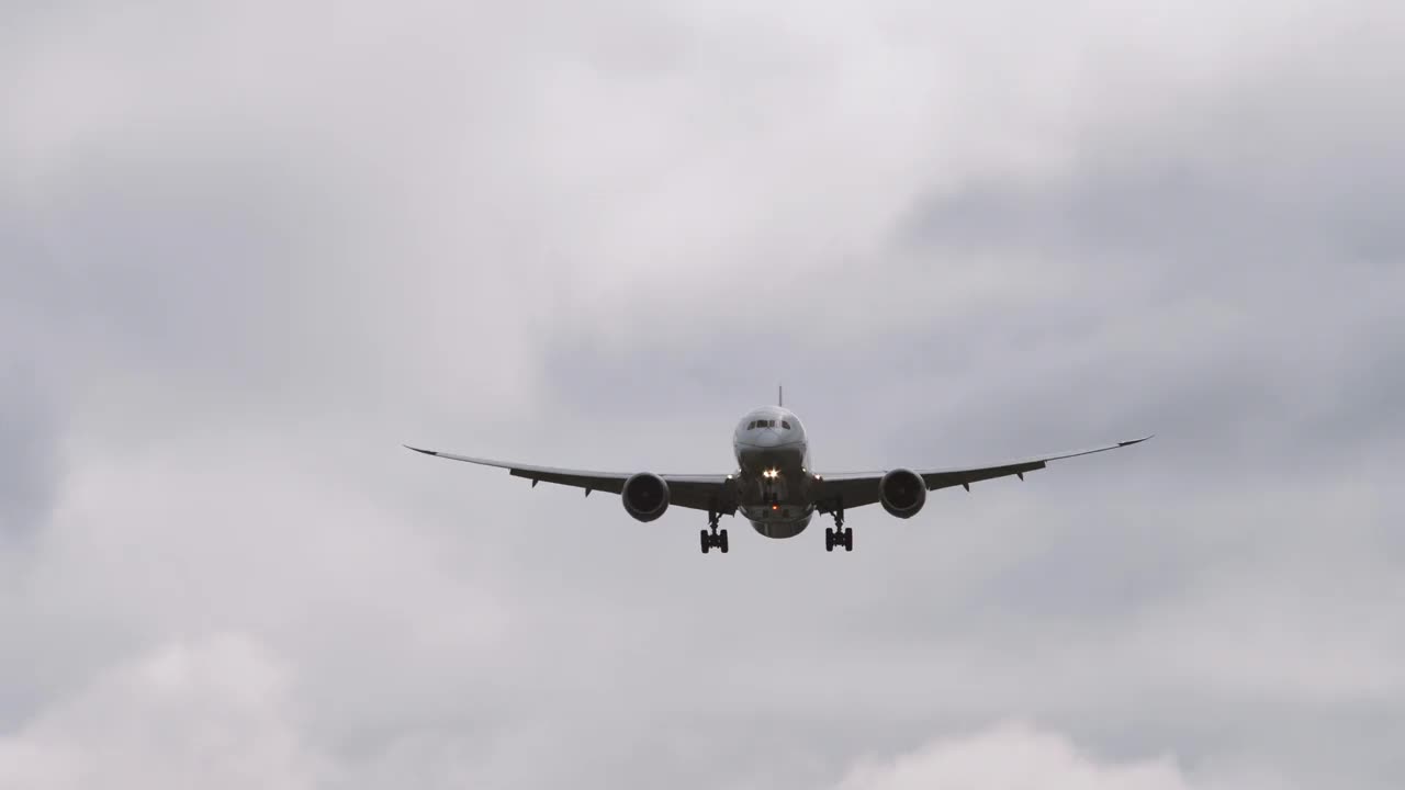 4k正面特写慢镜头跟踪拍摄的飞机航班降落在伦敦希思罗机场LHR在深灰色多云多风的日子视频素材