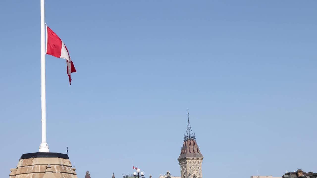 加拿大国旗在晴朗的蓝天下降半旗视频下载