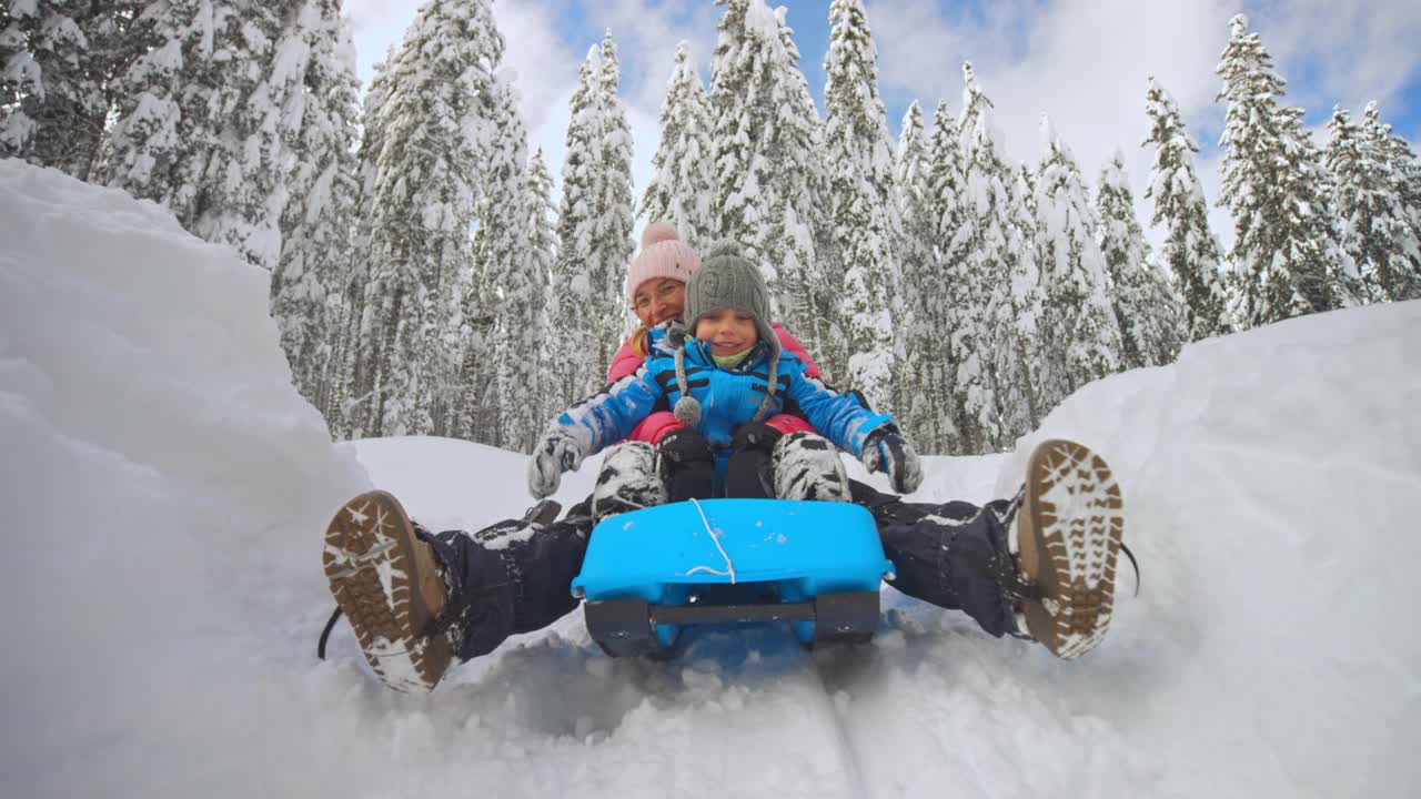 一位妇女带着她的小儿子从雪山上滑下来视频下载
