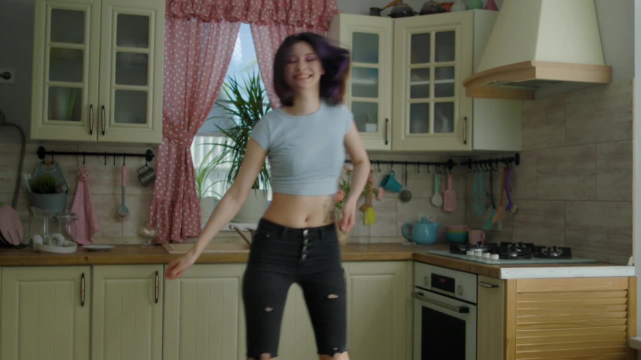 年轻漂亮的女人在厨房跳舞视频下载