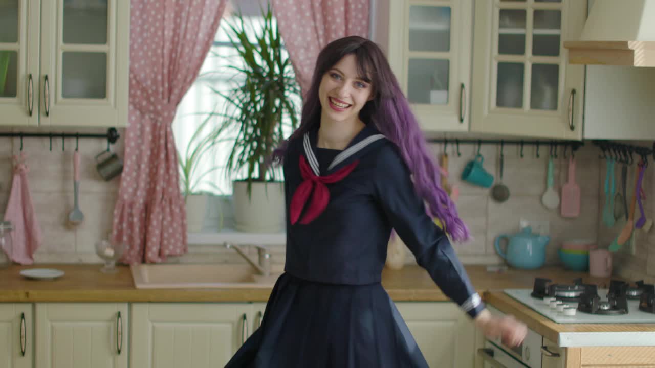 年轻漂亮的女人在家里的厨房里穿着日本服装跳舞视频下载