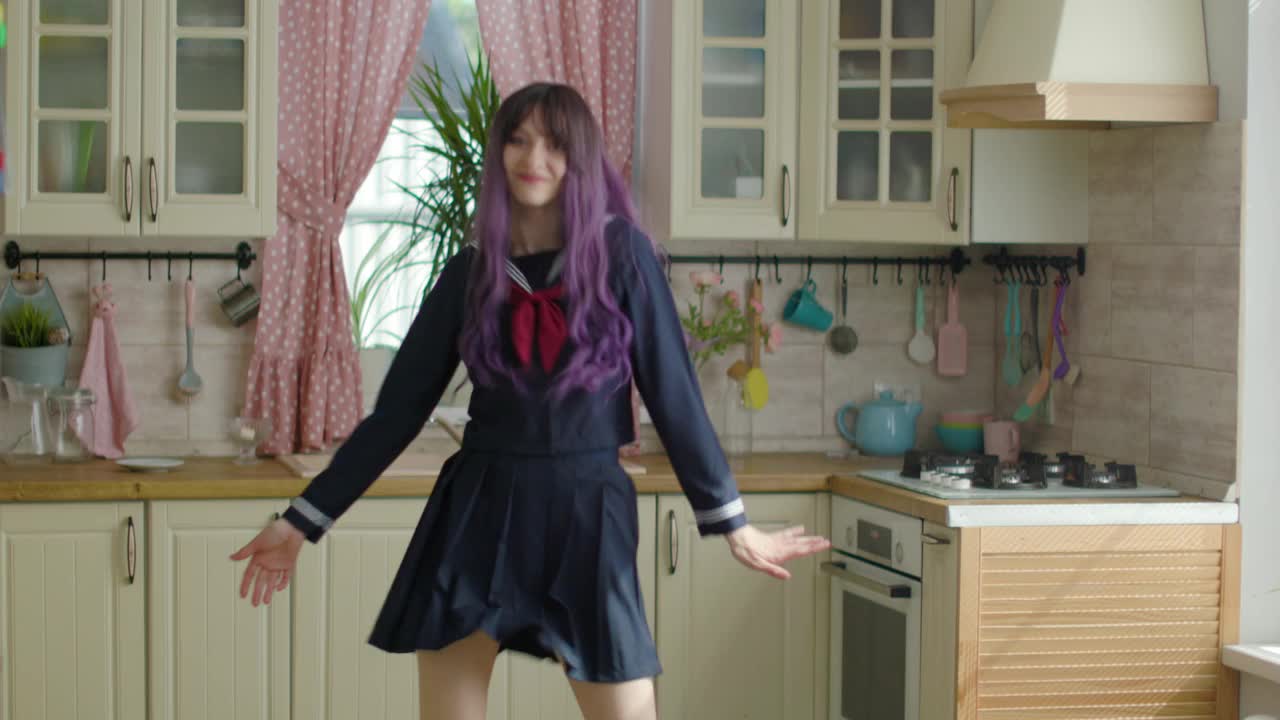 年轻漂亮的女人在家里的厨房里穿着日本服装跳舞视频下载