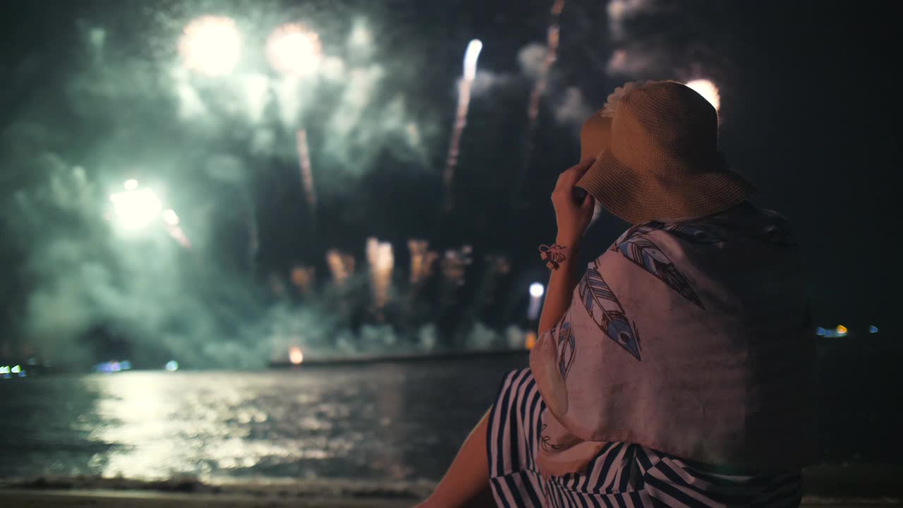 庆祝烟花，年轻女子看烟花在夜空视频下载