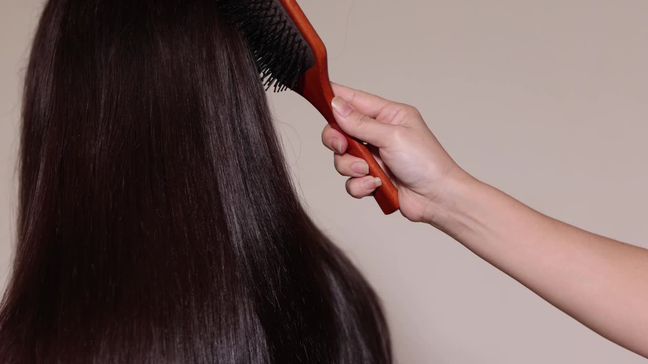 一个女人梳着一头长长的黑发。视频素材