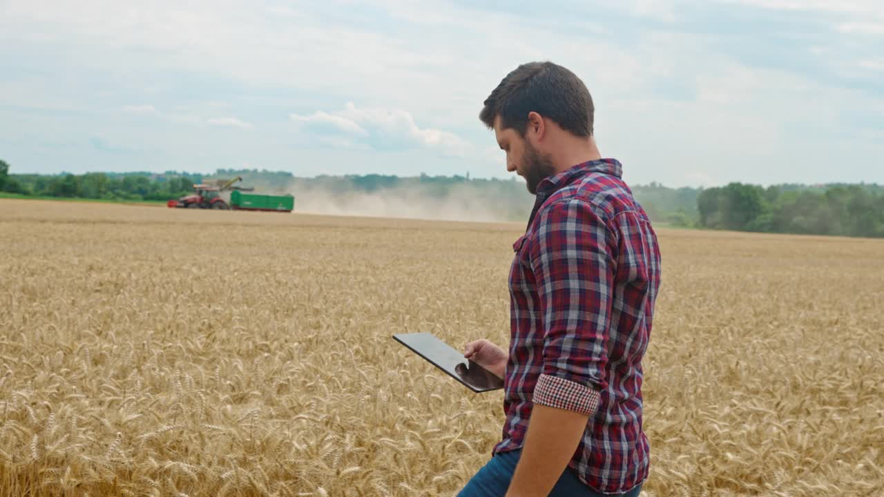 农夫在麦田中间用数码平板擦着额头视频下载