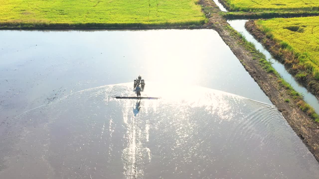 无人机的视角是农民驾驶拖拉机在日落时犁地视频下载