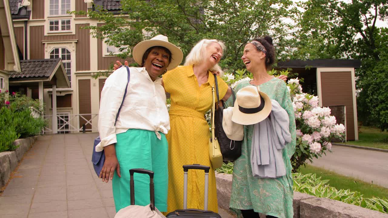 多种族的资深女性朋友们带着行李站在人行道上大笑视频下载