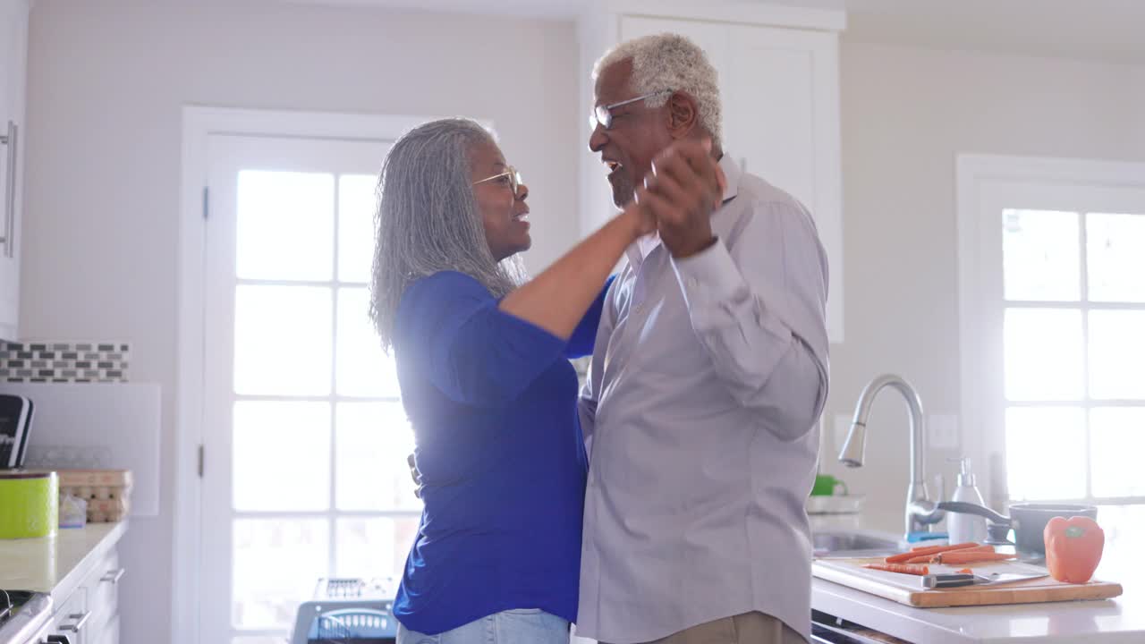 老年黑人夫妇一边在厨房做饭一边跳舞视频素材