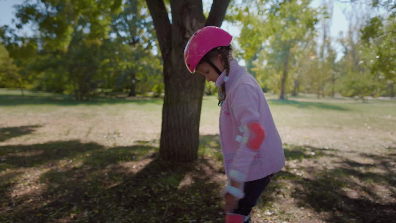戴着粉色头盔的女孩学习轮滑视频下载