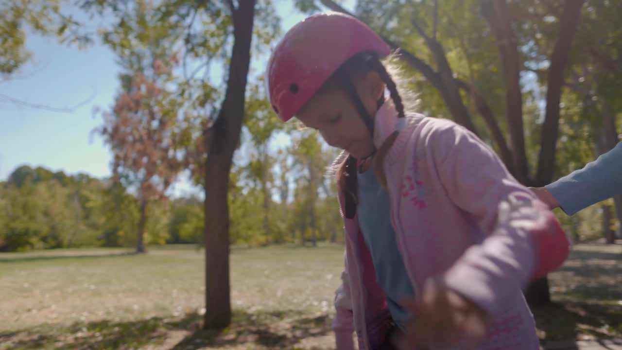 戴着粉色头盔的女孩学习轮滑视频下载
