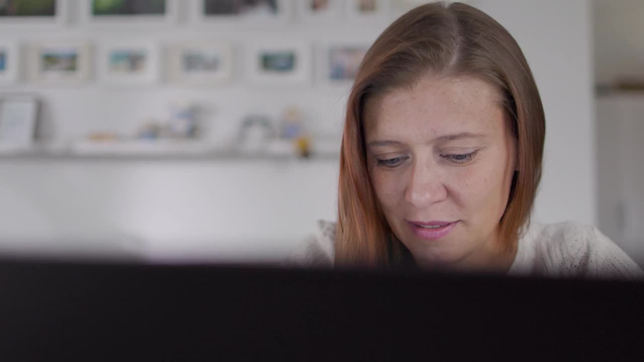 漂亮的红头发的成年女人在家里工作笔记本电脑视频下载